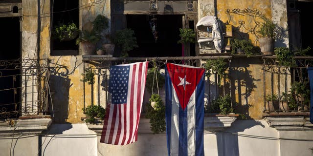 An American flag and a Cuban flag hang from a balcony in Old Havana.