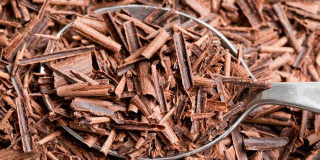 Dark chocolate shavings in metal spoon.