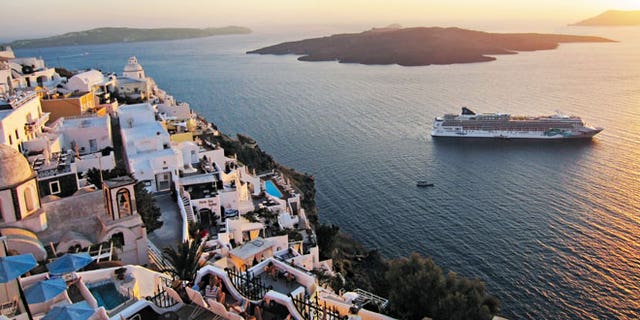 A Norwegian Cruise Line ship sails past Santorini, Greece.