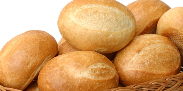 fresh baked rolls in a basket on white