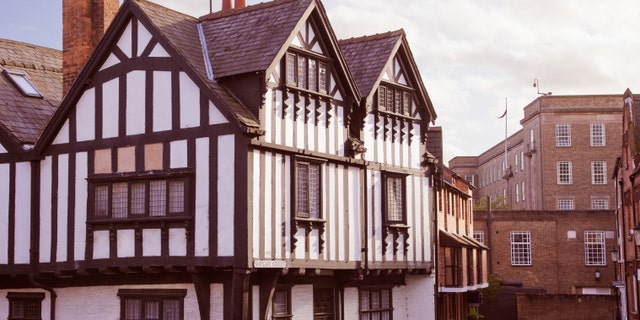 Half-Timbered English building by a small cobblestoned small street.
