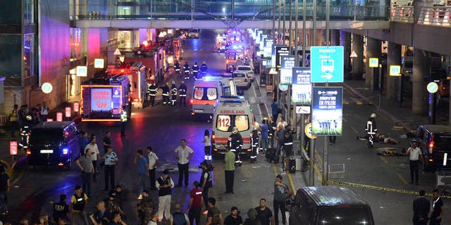 Medics and security members work at the entrance of the Ataturk Airport after explosions in Istanbul, Tuesday, June 28, 2016.