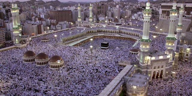 FILE- In this Monday, Feb. 18, 2002 file photo, thousands of Muslims gather around the holy Kabaa during evening prayer in the holy city of Mecca in Saudi Arabia. As Muslims from around the world stream into Mecca for the annual hajj pilgrimage this week, they come to a city undergoing the biggest transformation in its history. (AP Photo/Hasan Sarbakhshian, File)