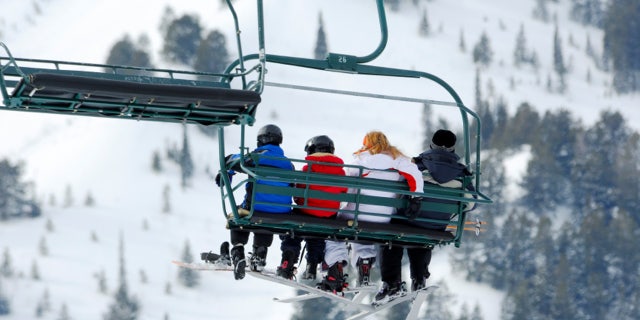 Family of four riding the chairlift at ski resort!