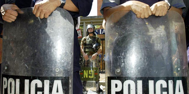CARACAS, VENEZUELA - JANUARY 7: National Guard soldiers guard tax offices (SENIAT) during a protest by the opposition of Venezuelan President Hugo Chavez January 7, 2003 in Caracus, Venezuela. Thousands of protesters marched on the tax office urging people to withold tax payments from the Venezuelan government. Chavez warned that not paying taxes is a crime and punishable with seven years in prison. (Photo by Susana Gonzalez/Getty Images)