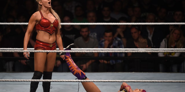 WWE wrestling stars Sasha Bank (R) and Charlotte Flair (L) fight during a WWE (World Wrestling Entertainment) women's fight at the Olympic hall in Munich, southern Germany, on November 3, 2016.