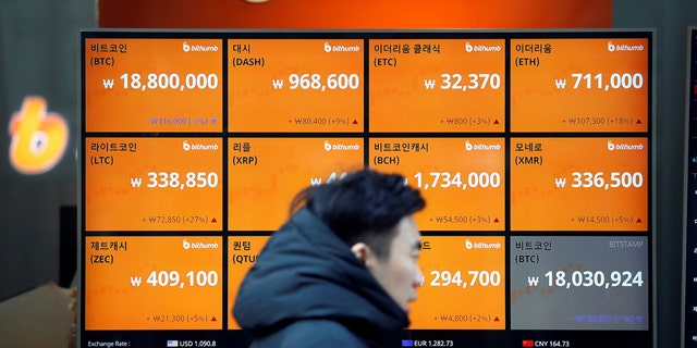 File photo: A man walks past an electric board showing exchange rates of various cryptocurrencies including Bitcoin (top L) at a cryptocurrencies exchange in Seoul, South Korea December 13, 2017. (REUTERS/Kim Hong-Ji)