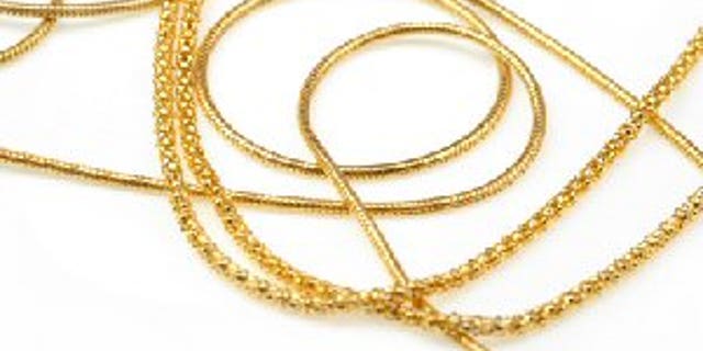 golden necklace close up on white paper