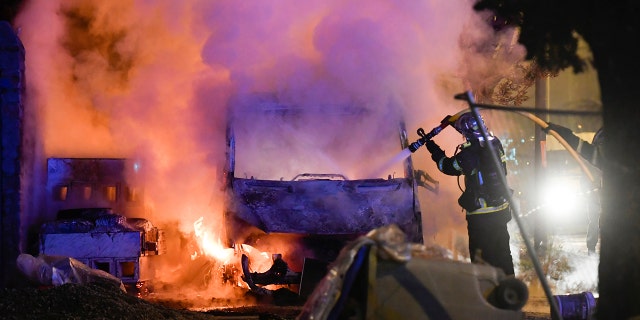 A firefighter works to extinguish a burning vehicle in Nante.