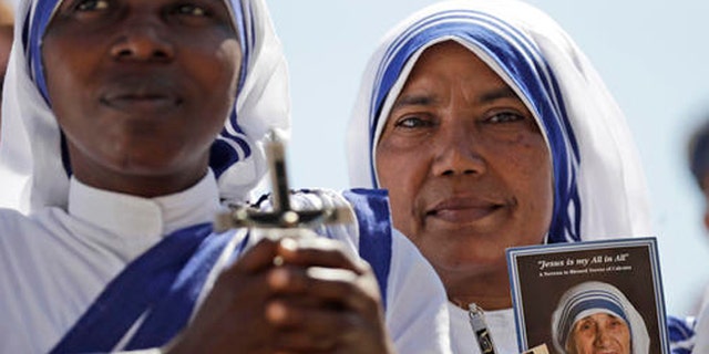 Missionaries of Charity nuns holds a photo of Mother Teresa in St. Peter's Square at the Vatican during a jubilee audience for workers and volunteers of mercy led by Pope Francis, Saturday, Sept. 3, 2016. The square hosts a ceremony Sunday expected to draw hundreds of thousands of admirers of Mother Teresa, a nun who before her death in 1997, cared for the destitute who were dying in the streets of India. (AP Photo/Alessandra Tarantino)