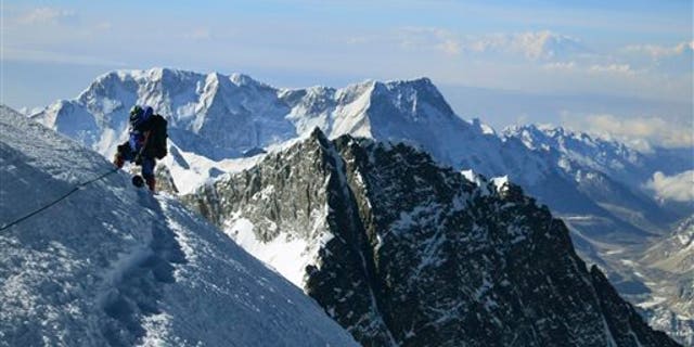 In this May 18, 2013 file photo released by mountain guide Adrian Ballinger of Alpenglow Expeditions, a climber pauses on the way to the summit of Mount Everest, in the Khumbu region of the Nepalese Himalayas.