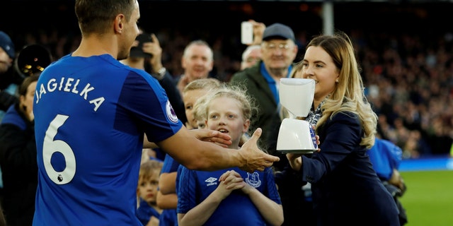 Everton captain Phil Jagielka collects the robot mascot before the match