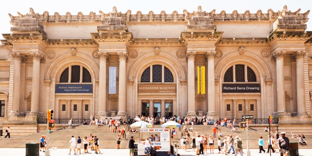 "New York, New York, USA - July 10, 2011: The recently renovated exterior of the Metropolitan Museum of Art in New York City. Visited by millions of people each year, this world renowned museum is located on 5th avenue between 80th and 84th streets. People can be seen entering and exiting through the main entrance as well as relaxing on the large staircase. A food cart provides refreshments for pedestrians."