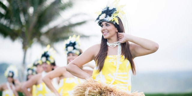Hawaiian cultural dancers doing a performance for tourists.
