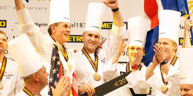 Mathew Peters of Team USA, center, celebrates on the podium with teammates after winning the "Bocuse d'Or" (Golden Bocuse) trophy, in Lyon, central France, Wednesday, Jan. 25, 2017. The contest, known as the Olympics of the food world, was started in 1987 by Lyon chef Paul Bocuse to reward young international culinary talents.