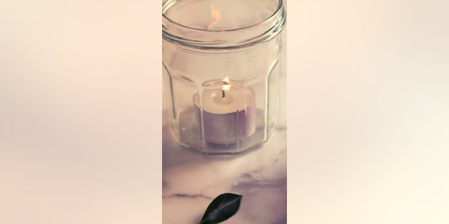 Vintage feel camellia flower and jar candle on marble