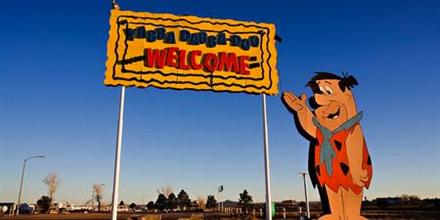 Fred Flintstone welcomes visitors to Bedrock City.