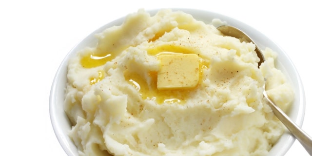 Bowl of mashed potato with melting butter and a sprinkle of nutmeg.