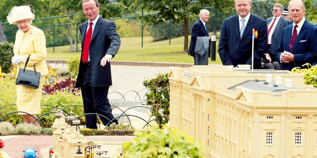 Queen Elizabeth (L) and the Duke of Edinburgh look at a miniature version of Buckingham Palace during a visit to Legoland in Windsor, U.K.