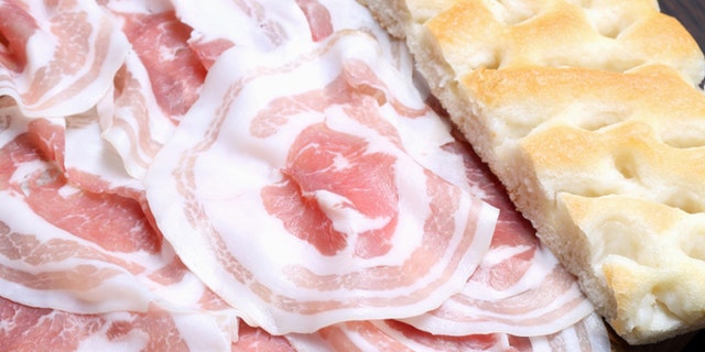 Bacon slices with focaccia on wooden cutting board