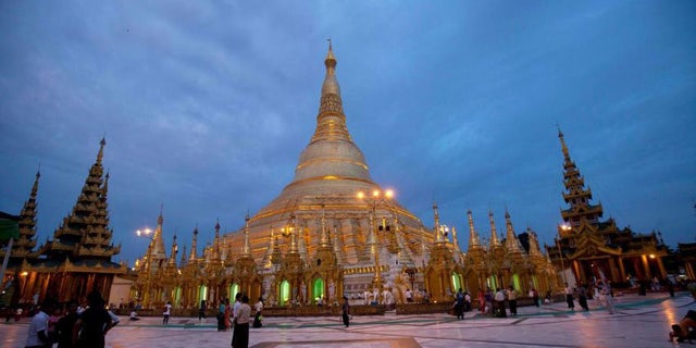 Buddhist devotees visit Myanmar's famous Shwedagon Pagoda as its illuminated in Yangon, Myanmar on Aug. 13, 2014.