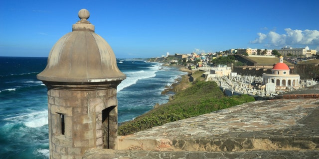 Sentry box overlooking the Atlantic Ocean at 'El Morro' (Castillo San Felipe del Morro) and the La Perla district of Old San Juan, Puerto Rico, including an old cemetery