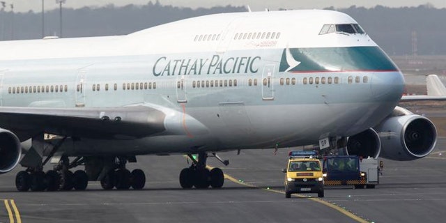 A Cathay Pacific Boeing B747-400 Aircraft is towed down the runway.