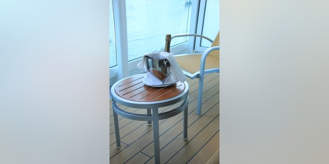 A bottle of champagne and glasses, waiting in a bucket to be served