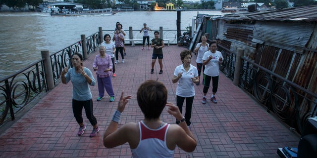 People exercise beside the Chao Phraya river in Bangkok September 24, 2014. Picture taken September 24, 2014. REUTERS/Athit Perawongmetha