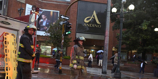 Firefighters stand outside the Centro Andino shopping center in Bogota, Colombia, Saturday, June 17, 2017.