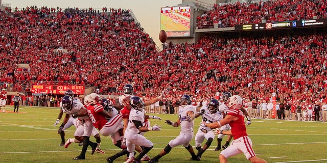 In this image from Nov. 2, 2013, a scrum of Nebraska and Northwestern players follow a tipped ball. (AP Photo/Nati Harnik)