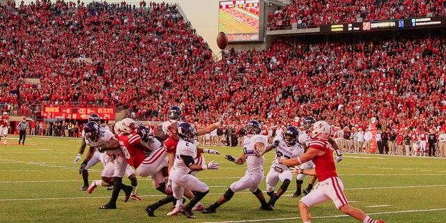 In this image from Nov. 2, 2013, a scrum of Nebraska and Northwestern players follow a tipped ball. (AP Photo/Nati Harnik)