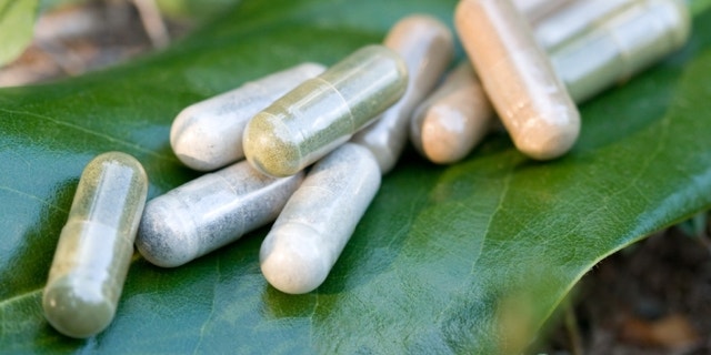 Herbal medicine capsules in a nature environment.