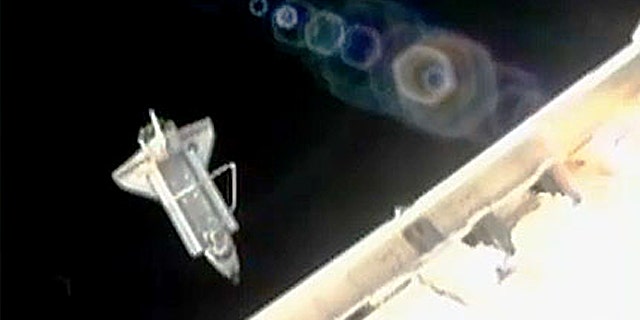 Space shuttle Discovery performs its flyaround shortly after undocking from the International Space Station.