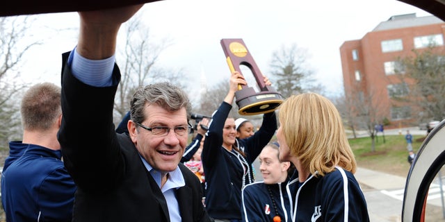 Connecticut head coach Geno Auriemma watches fans cheering his team as they ride a double-decker bus during a parade through campus, Wednesday, April 10, 2013 in Storrs, Conn., honoring the team's NCAA women's college basketball championship. UConn defeated Louisville 93-60 in the championship game of the women's Final Four on Tuesday in New Orleans. (AP Photo/Jessica Hill)