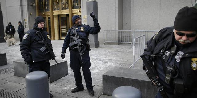 FILE - In this Jan. 22, 2015 file photo, security police watch over the entrance to a federal courthouse in New York where the trial of a man charged with conspiring in the 1998 bombings that killed 224 people at two U.S. embassies in Africa is taking place. Fears over the terror attacks in Paris have raised security at the city's federal courthouses to levels not seen since the days following the Sept. 11, 2001, attacks. (AP Photo/Seth Wenig, File)