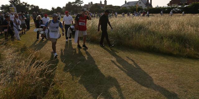 Tiger Woods of the US walks off the 18th hole after finishing his round on the second day of the British Open Golf championship at the Royal Liverpool golf club, Hoylake, England, Friday July 18, 2014. (AP Photo/Jon Super)