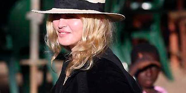 March 29, 2009: Pop star Madonna is watched by local children during a visit to Chinkhota village near Lilongwe, Malawi.