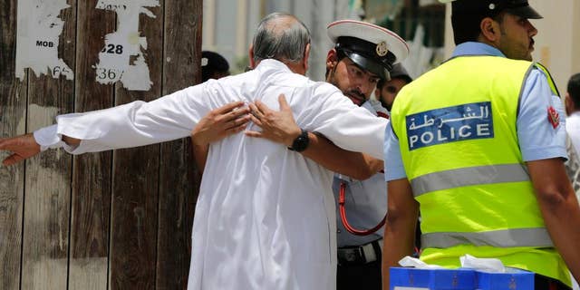 FILE- In this Friday, June 5, 2015 file photo, Bahraini community police officers search worshipers outside a Shiite Muslim mosque ahead of mid-day prayers in Manama. Bahraini authorities say two policemen have been killed and many injured in a bomb attack south of the capital. The Interior Ministry said on its Twitter feed on Tuesday, July 28, 2015 that the officers were killed in a "terror blast" in the largely Shiite community of Sitra. (AP Photo/Hasan Jamali, File)