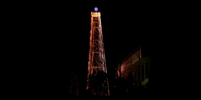 A 30-meter-tall (100-foot-tall) steel Christmas tree with about 30,000 light bulbs, is lit by Christian groups at the western mountain peak, known as Aegibong, in Gimpo, South Korea, Saturday, Dec. 22, 2012. The Christmas tree would be visible by North Koreans living near the Demilitarized Zone that divided the two Koreas. (AP Photo/Lee Jin-man)