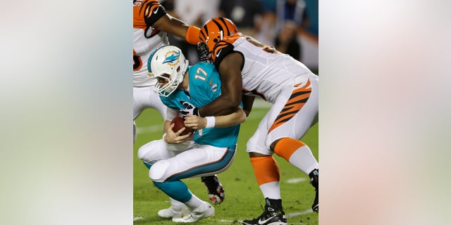 Miami Dolphins quarterback Ryan Tannehill (17) is sacked by Cincinnati Bengals defensive tackle Geno Atkins during the first half of an NFL football game, Thursday, Oct. 31, 2013, in Miami Gardens, Fla. (AP Photo/Wilfredo Lee)