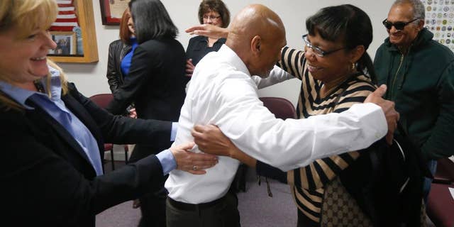 Joseph Sledge hugs his sister Barbara Kinlaw after a special session of superior court in Whiteville, N.C. on Friday, Jan. 23, 2015. Sledge, 70, was freed from prison Friday, after a panel of judges found that he was wrongly convicted in the stabbing deaths of a mother and daughter nearly four decades ago. Christine Mumma, director of the North Carolina Center on Actual Innocence, is to the left. (AP Photo/The News & Observer, Ethan Hyman)
