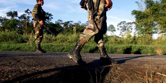 CAQUETA, COLOMBIA - JULY 31: Colombian soldiers patrol the highway that leads to San Vicente del Caguan from their base in Caqueta, Colombia on July 31, 2002. Despite a strong military presence in the former demilitarized zone, FARC guerrillas still maintain their control over the territories. (Photo by Carlos Villalon/Getty Images.)