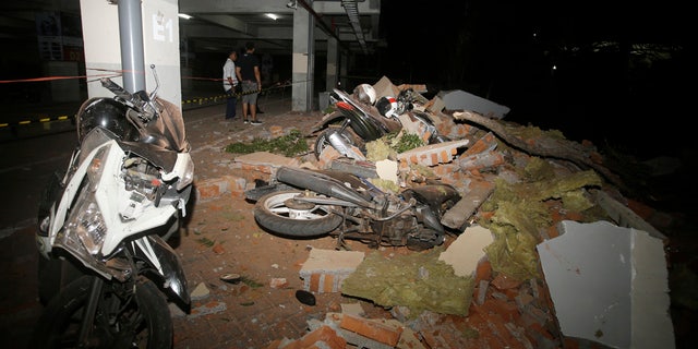 Debris on top of a motorcycles after an earthquake in Bali, Indonesia, Sunday, Aug. 5, 2018.