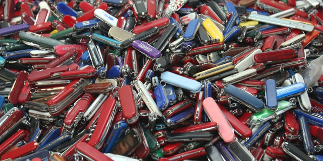 FILE - In this Sept. 26, 2006, file photo, knives of all sizes and types are piled in a box at the State of Georgia Surplus Property Division store in Tucker, Ga., and are just a few of the hundreds of items discarded at the security checkpoints of Hartsfield-Jackson Atlanta International Airport that will be for sale at the store. Federal officials say they’re delaying a policy that would allow passengers to carry small knives, bats, and other sports equipment onto airliners. The Transportation Security Administration said Monday, April 22, 2013, that the policy change has been delayed to accommodate feedback from an advisory committee made up of aviation industry, consumer, and law enforcement officials.(AP Photo/Gene Blythe, File)
