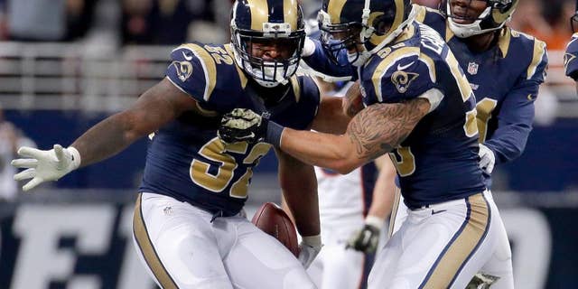 St. Louis Rams linebacker Alec Ogletree, left, is congratulated by teammates James Laurinaitis, center, and Janoris Jenkins after intercepting a pass during the fourth quarter of an NFL football game against the Denver Broncos, Sunday, Nov. 16, 2014, in St. Louis. (AP Photo/Charlie Riedel)