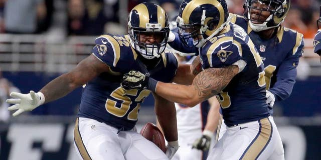 St. Louis Rams linebacker Alec Ogletree, left, is congratulated by teammates James Laurinaitis, center, and Janoris Jenkins after intercepting a pass during the fourth quarter of an NFL football game against the Denver Broncos, Sunday, Nov. 16, 2014, in St. Louis. (AP Photo/Charlie Riedel)