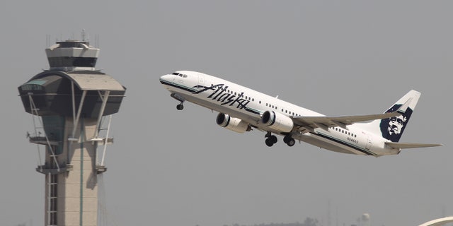 LOS ANGELES, CA - APRIL 22: An Alaska Airlines jet passes the air traffic control tower at Los Angles International Airport (LAX) during take-off on April 22, 2013 in Los Angeles, California. Delays have been reported throughout the nation because of the furloughing of air traffic controllers under sequestration. The average delay overnight in the Southern California Terminal Radius Approach Control (TRACON) was was three hours. (Photo by David McNew/Getty Images)
