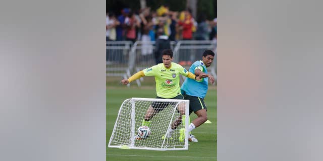 Brazil's Hernanes, left, and Paulinho, practice during a training session at the Granja Comary training center in Teresopolis, Brazil, Monday, June 30, 2014. Brazil will face Colombia on July 4 in a quarter-final match of the 2014 soccer World Cup. (AP Photo/Andre Penner)