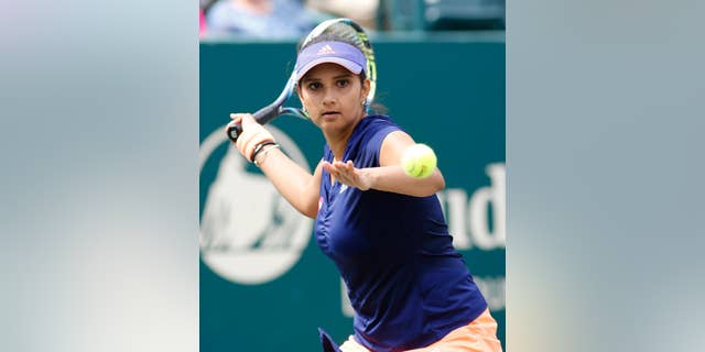 Sania Mirza, of India, returns to Alla Kudryavtseva and Anastasia Pavlyuchenkova during a doubles final match at the Family Circle Cup tennis tournament in Charleston, S.C., Sunday, April 12, 2015. Mirza and Martina Hingis won 6-0, 6-4. (AP Photo/Mic Smith)